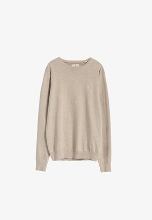 Jersey beige claro de tela suave, con cuello redondo, mangas largas y puños acanalados, con un pequeño detalle de logo en la parte frontal.