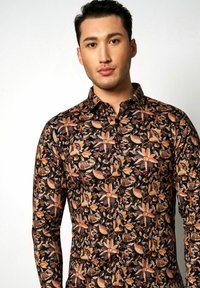 Schwarzes Hemd mit Knöpfen, das ein florales Muster in den Farben Orange, Beige und Hellbraun aufweist; aus einem leichten Stoff mit glatter Textur gefertigt.