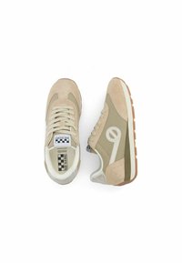 Beige suède sneakers met een gestructureerde afwerking en lichte groene accenten. Voorzien van een opvallend wit logo en een rubberen gumzool. Platte veters.