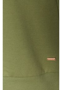Olivgrüner, gerippter Sweatshirt aus Stoff mit strukturierter Oberfläche. Mit einem kleinen metallischen Markenschild am unteren Rand.