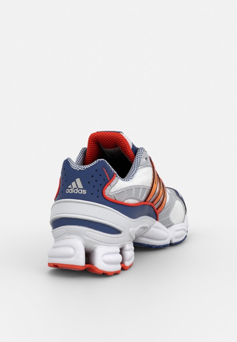 Scarpe da corsa Adidas con una tomaia in rete grigia, accenti arancioni e blu navy, un tallone imbottito e una suola bianca distintiva e segmentata.