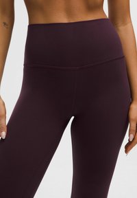 Kalhoty s vysokým pasem v tmavě burgundské barvě vyrobené z pružného materiálu, s hladkým povrchem a plochými švy pro pohodlí a dokonalé padnutí.