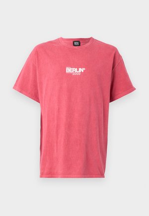Roze katoenen t-shirt met een ronde hals en korte mouwen, voorzien van witte bedrukte tekst "BERLIJN 2009" op de voorkant. Gladde textuur.