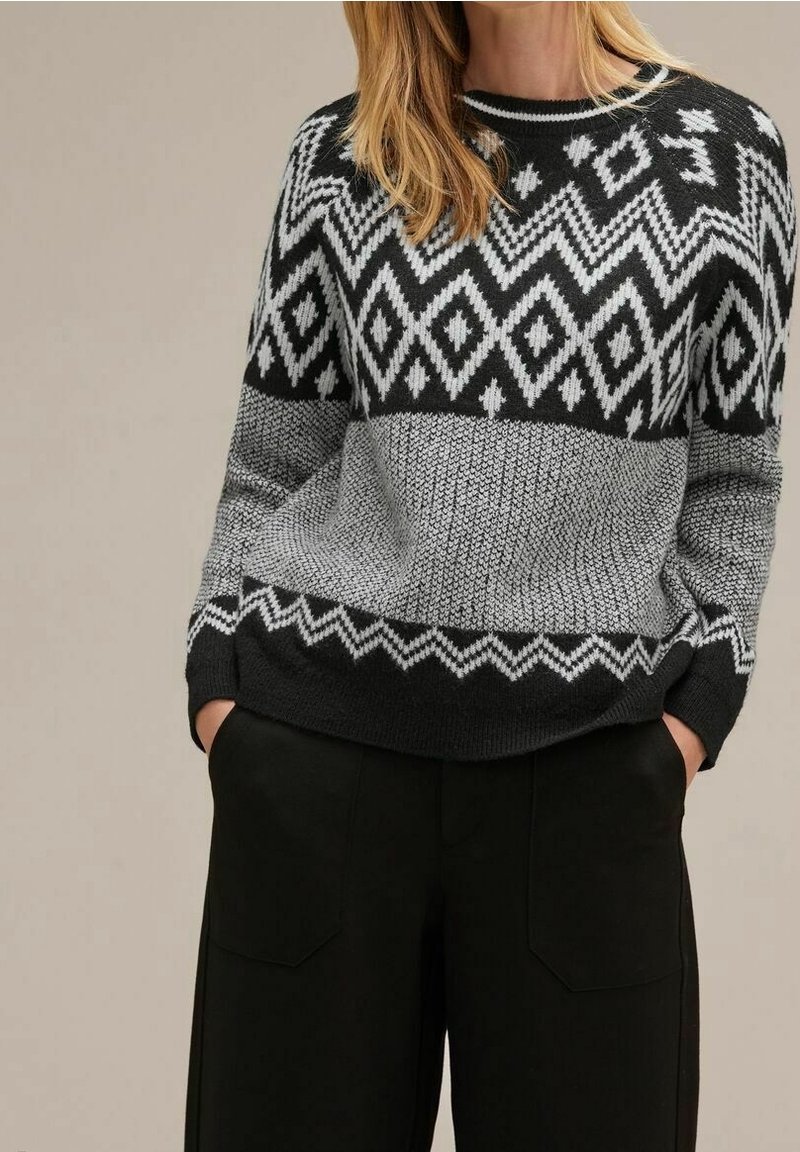Stickad tröja i svart och grått med geometriska mönster. Har en rundad halsringning, ribbade ärmslut och en texturerad kropp.