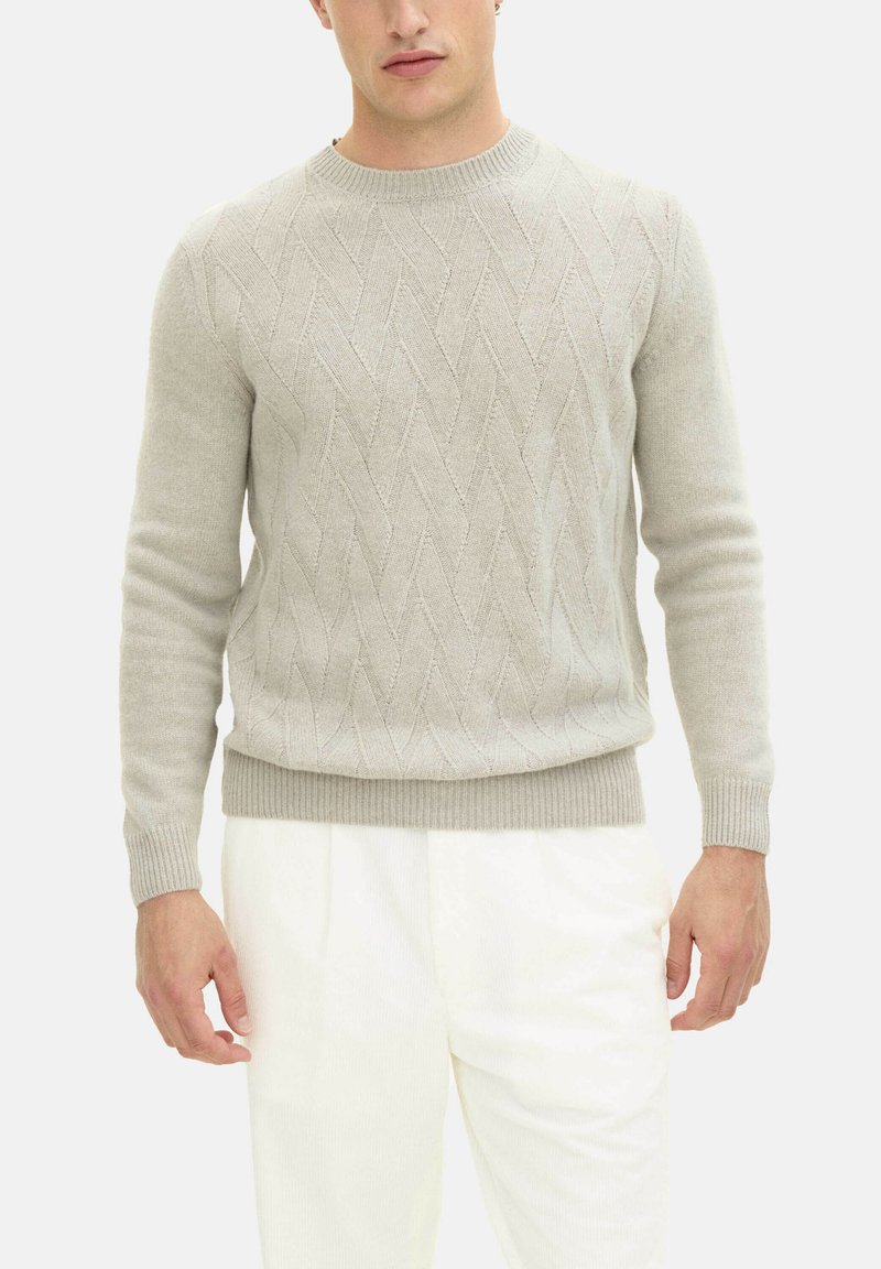 Ljusgrå stickad tröja med kabelmönster, rundad halsringning och ribbade ärmslut och nederkant, tillsammans med vita plisserade byxor.