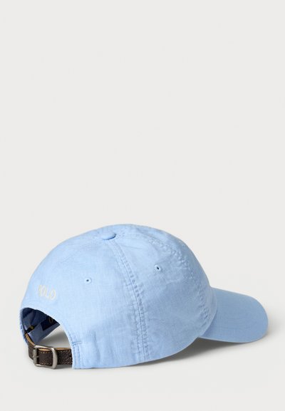 Lyseblå bomullskaps med strukturert topp, buet skjerm og justerbar brun lærrem. Har brodert "POLO"-logo.