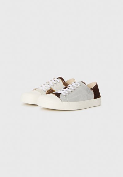 Sneakers med en grå och brun färgskala, med mocka och släta texturer, vita snören och en rund beige gummisula.