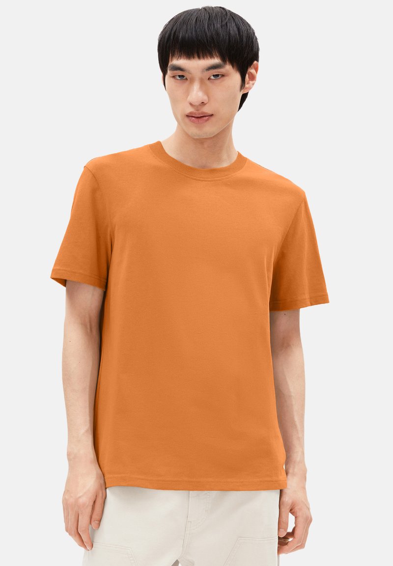 Kurze, orange Baumwoll-T-Shirt mit Rundhalsausschnitt und geradem Saum. Einfaches Design ohne erkennbare Muster oder Akzente.