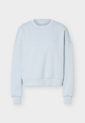 Svijetloplavi pulover s okruglim izrezom, dugim rukavima i rebrastim manšetama i rubom, položen na bijelu pozadinu.