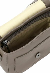 Borsa a tracolla in pelle marrone con un interno rivestito beige. Presenta un scomparto con zip e chiusura a bottone automatico. Texture morbida, forma rettangolare.