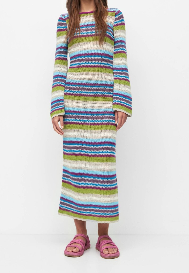 Robe en maille rayée aux teintes bleues, vertes et violettes, dotée de manches longues et d'une silhouette droite, associée à des sandales à lanières roses.