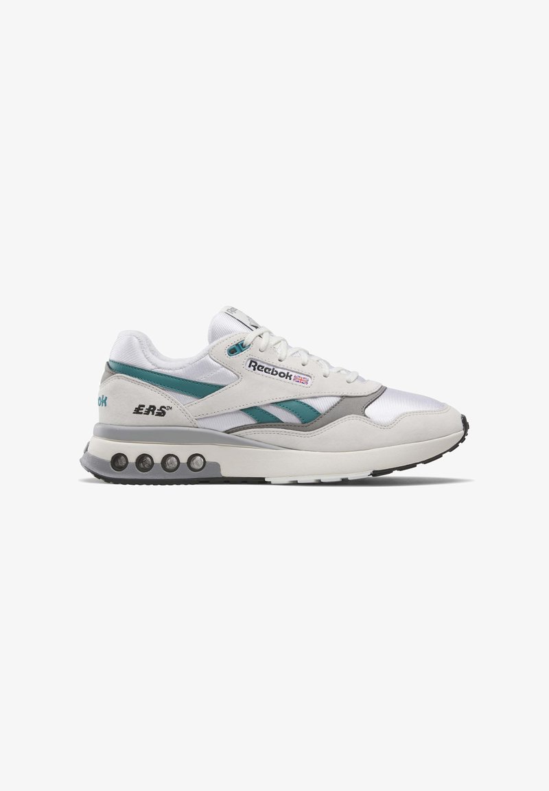 Baltie sporta apavi ar tumši zilu un pelēku akcentu. Iekļauj mīkstu zoli, auklu dizainu un izteiksmīgu Reebok zīmolu sānos.