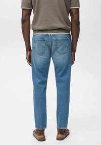 Jasnoniebieskie dżinsy z prostą nogawką, wyposażone w dwie tylne kieszenie i subtelne przetarcia. Materiał wydaje się wytrzymały o gładkiej fakturze.