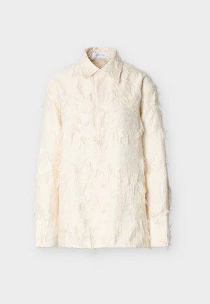 Krémovo sfarbená košeľa z textúrovaného materiálu s roztŕhanými detailmi, vybavená golierom, dlhými rukávmi a zapínaním na gombíky. Vidieť sú tri gombíky.