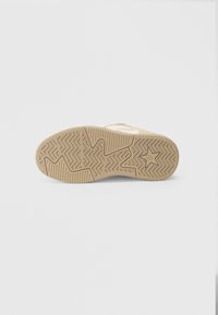 Sola de borracha com padrão espinha de peixe em castanho claro. Apresenta um acabamento liso com uma impressão do logótipo de estrela perto da zona do calcanhar.