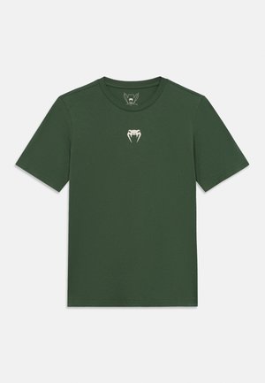 Zelena kratkih rukava majica od mekog pamuka, s bijelim logotipom zmije na prsima. Klasični okrugli izrez, minimalistički dizajn.