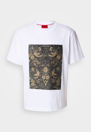 Witte katoenen t-shirt met een vierkant donker bloemmotief met gouden accenten en vogelmotieven. Label "HUGO" bovenaan het ontwerp.