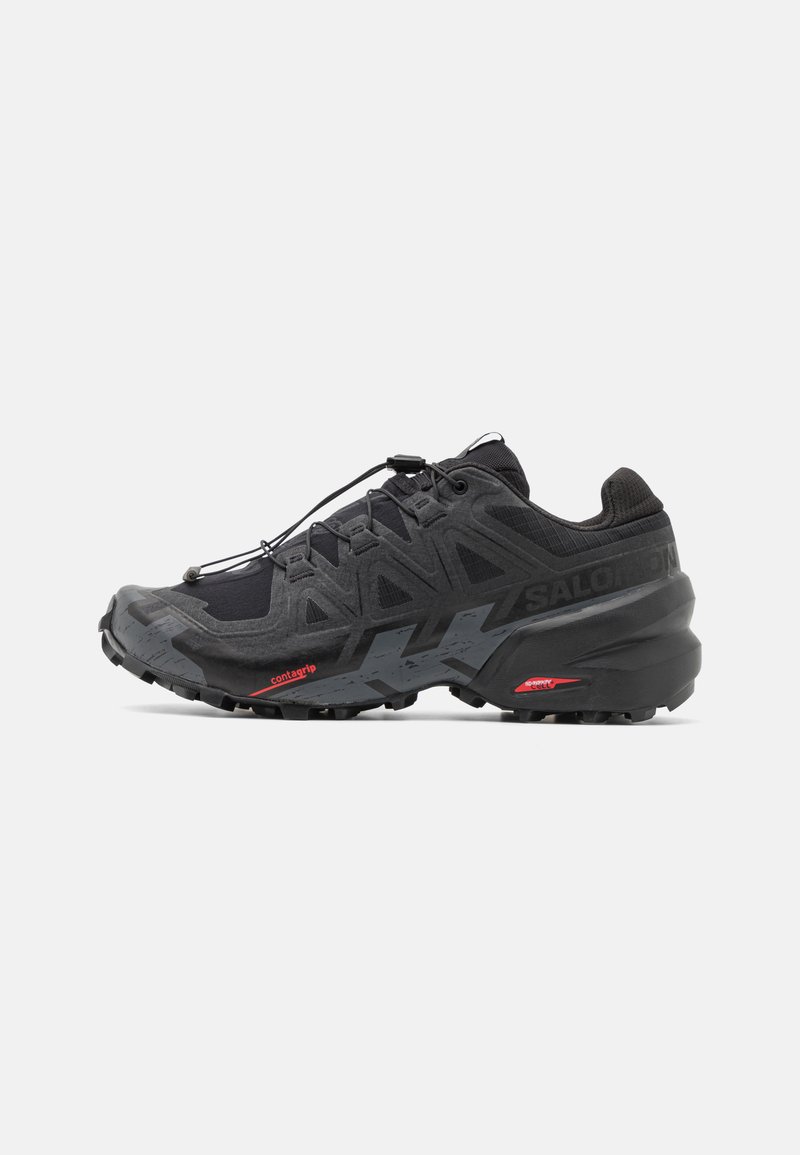 Baskets de running noires avec tige en synthétique, design texturé et accents rouges contrastants. Équipées d'un système de laçage sécurisé et d'une semelle extérieure robuste.