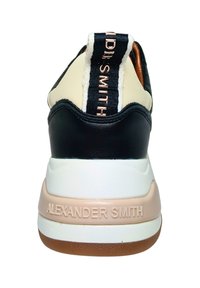 Baskets noir et blanc avec une tige texturée, semelle intermédiaire beige et "ALEXANDER SMITH" embossé sur le talon. Comprend une languette en tissu.