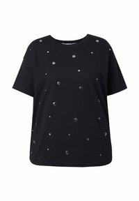 Camiseta negra de manga corta con un ajuste holgado, que presenta tachuelas metálicas de diferentes tamaños dispuestas por toda la tela. Material de algodón suave.