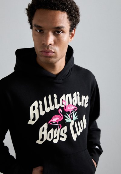 Hoodie noir avec une poche kangourou, présentant un texte blanc "Billionaire Boys Club" et une broderie de flamant rose entourée de feuilles vertes.