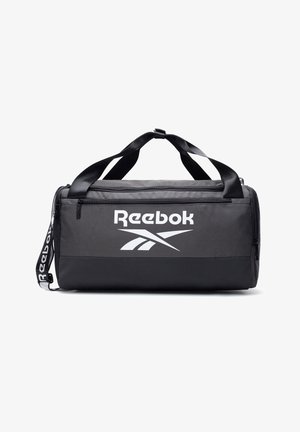 Czarna i szara torba sportowa Reebok z dwoma uchwytami, paskiem na ramię, przednią kieszenią na zamek oraz białym logo na jednolitym tle.
