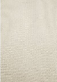 Tissu tricoté couleur crème avec un motif de maille fin et uniforme, créant une texture douce et confortable.