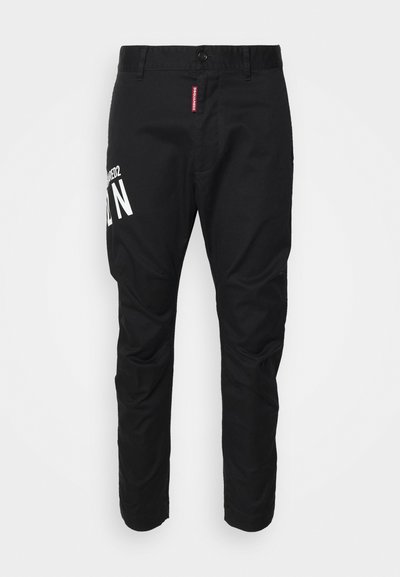 Black cotton trousers with a slim fit, featuring a white graphic print on the left leg and a standard button closure at the waistband.