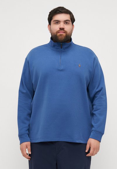 Felpa blu con zip e maniche lunghe, colletto a coste e texture di tessuto. Presenta un logo ricamato sul lato sinistro del petto.