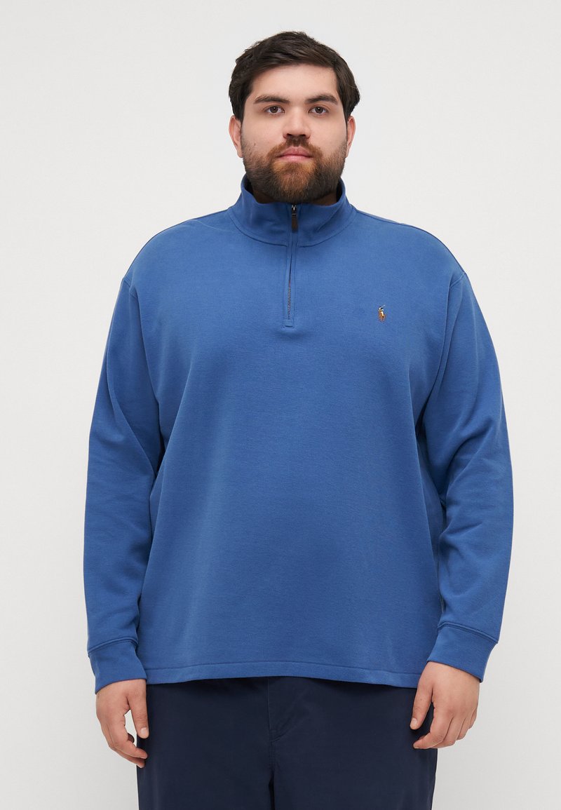 Blue zip-up sweatshirt with long sleeves, ribbed collar, and fabric texture. Features embroidered logo on the left chest.