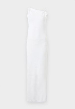 Fehér, ujjatlan, padlóig érő ruha, testhez simuló sziluettel és egyetlen vállpánttal, amelyet bal oldalon csomóként kötöttek meg.