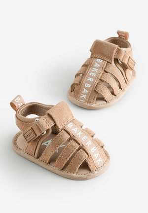 Barna velúr szandálok, nyitott orral, több szíjjal és logóval. Puha textúra párnázott talppal a kényelemért.