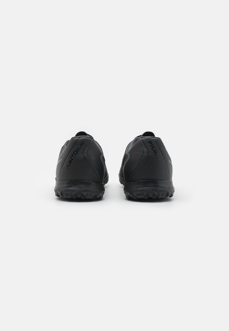 Zapatillas deportivas negras con una superficie texturizada, que presentan un diseño elegante, suela de goma y una marca en el talón. Estilo minimalista.