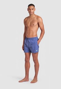 Blauwe zwembroek gemaakt van lichtgewicht stof met een elastische tailleband, voorzien van een zijzak en een klein logo in contrasterende kleur.