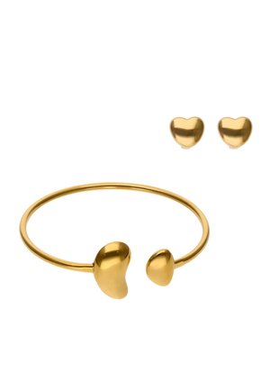 Goudkleurige armband met hartvormige uiteinden en bijpassende hartvormige oorknopjes, gladde afwerking, minimalistisch ontwerp en afgeronde randen.