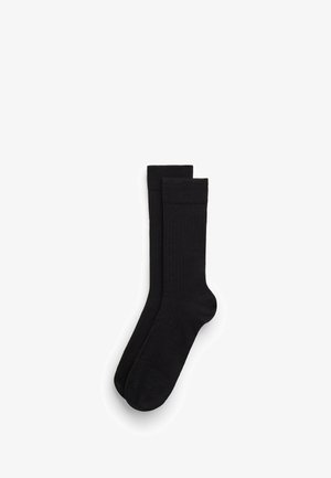 Sorte ribbede strømper med et ensartet design og en glat tekstur, afsluttet med en kant øverst. Velegnet til forskellige anledninger.