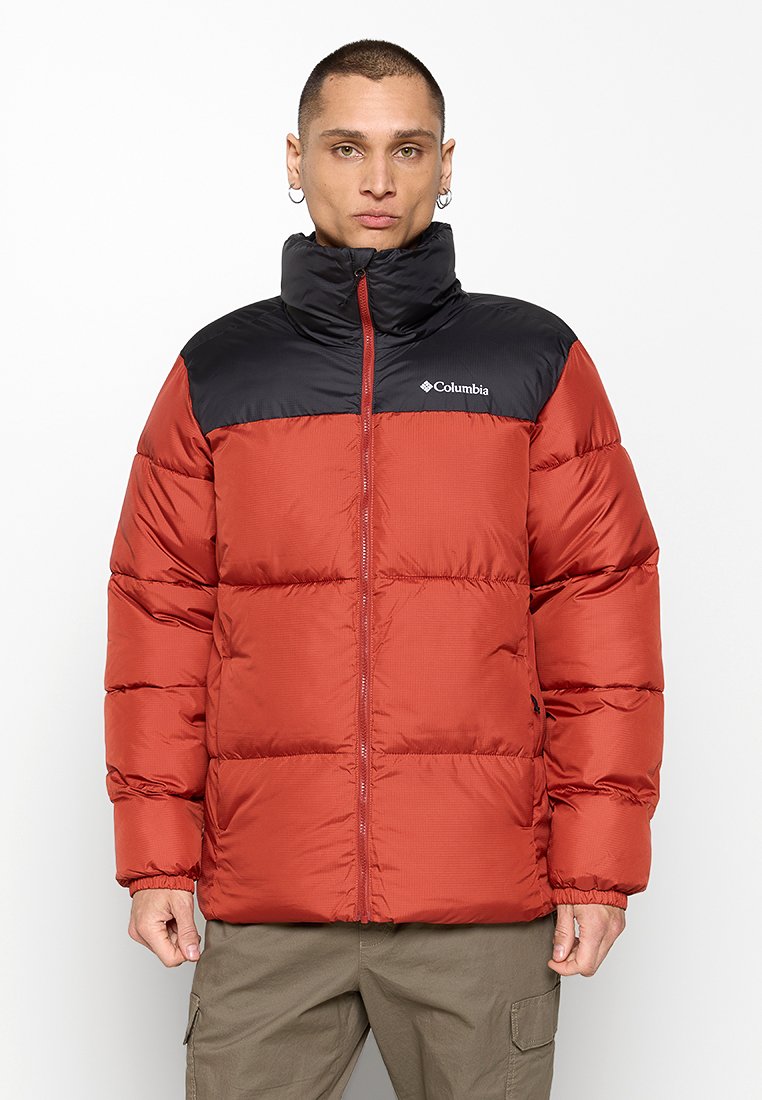 Czerwona i czarna kurtka puchowa z wysokim kołnierzem, zapięciem na zamek i pikowanym wzorem. Posiada logo Columbia na piersi oraz boczne kieszenie.