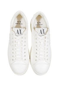 Par de zapatillas blancas de Armani Exchange con cordones, vistas desde arriba, mostrando el logo de la marca en las suelas interiores y en las etiquetas de la lengüeta.