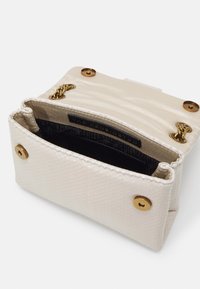 Borsa a tracolla di un bianco leggermente strutturato con una finitura liscia, dotata di accessori in oro e di una fodera interna nera. La chiusura è dotata di un bottone a pressione.