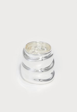 Inel argintiu cu un finisaj neted și lustruit, având trei benzi curbe care creează un design stratificat. Interiorul are un model texturat.