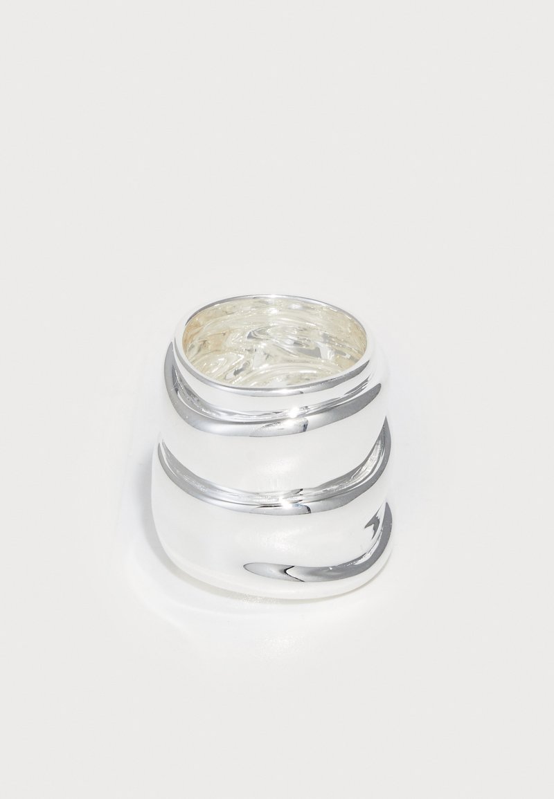 Ασημένιο δαχτυλίδι με λείο, γυαλισμένο φινίρισμα, που διαθέτει τρεις καμπύλες λωρίδες που δημιουργούν ένα στρωτό σχέδιο. Το εσωτερικό έχει υφή.