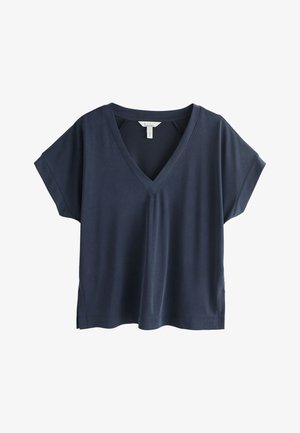 Granatowy T-shirt z krótkim rękawem, dekoltem w serek, luźnym krojem, prostym dołem i przeszyciami na białym tle.