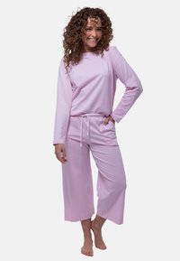 Rosa lounge-set i mjukt tyg, med långa ärmar och vida byxor med justerbar dragsko i midjan.