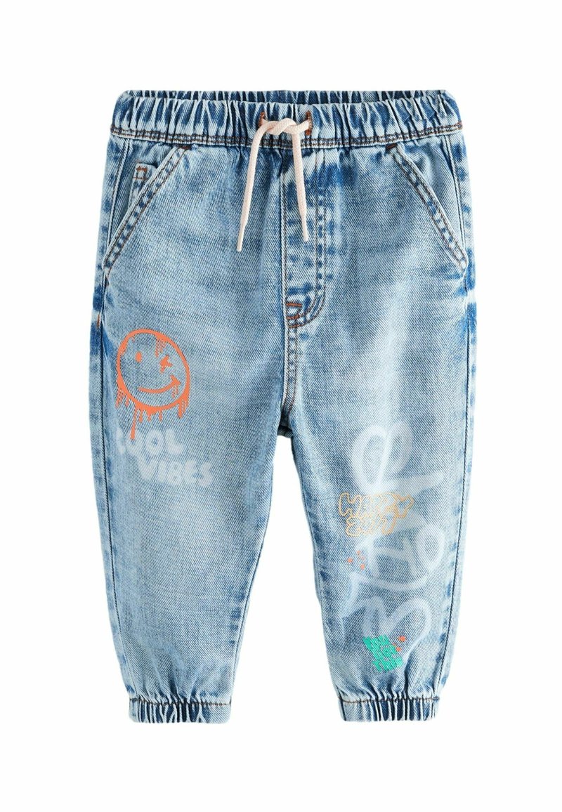 Pantalon jogger en denim bleu clair avec taille et poignets élastiques, cordon blanc et imprimés graphiques colorés incluant un smiley qui fait un clin d'œil et du texte.
