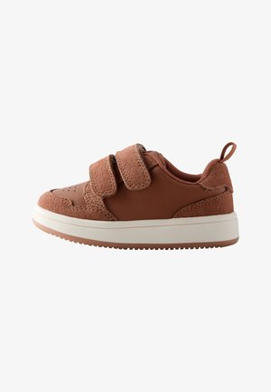 Basket marron pour enfants avec deux bandes Velcro réglables, textures en suède et lisse, semelle blanche et languette au talon.