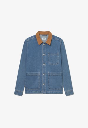 Τζάκετ από τζιν με καφέ σουέτ γιακά, μακριά μανίκια, εμπρόσθιες κουμπότρυπες και δύο μεγάλες μπροστινές τσέπες. Διαθέτει κι μια τσέπη στο στήθος.