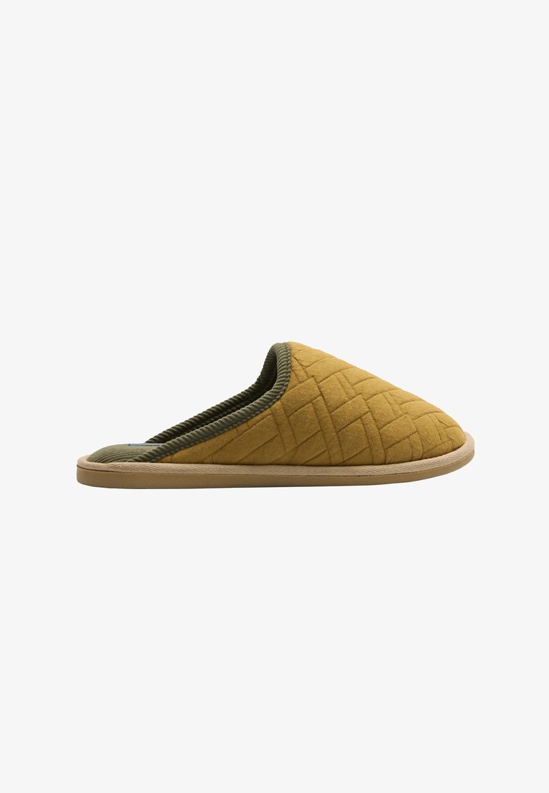 Zapatilla amarilla acolchada con forro textil verde, que presenta una punta redondeada, acentos trenzados y una suela de goma marrón.