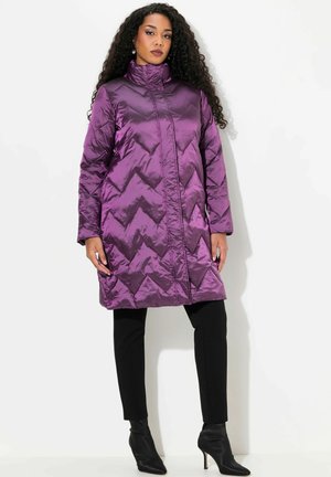 Purple quilted long coat with a high collar, featuring a chevron pattern, paired with black fitted pants and black ankle boots.