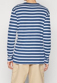 Langarmshirt mit horizontalen navyblauen und weißen Streifen, aus weichem Stoff, mit Rundhalsausschnitt und lässiger Passform.