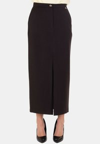 Gonna nera a matita con spacco frontale, design sartoriale, chiusura con bottone e tasche laterali, realizzata in tessuto liscio. Abbinata a tacchi neri.